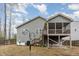 Backyard view featuring the home's gray siding, screened porch, and a well-maintained lawn at 1600 Frog Hollow Way, Wake Forest, NC 27587