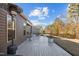 Spacious deck with outdoor seating and a built in heater, overlooking a grassy backyard with mature trees at 1713 Wrenn Rd, Durham, NC 27703