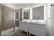 Elegant bathroom featuring double vanities, LED mirrors, and a tiled shower at 1713 Wrenn Rd, Durham, NC 27703