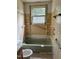 This bathroom has a green tub, shelves, a window, and a toilet at 186 Frank Cash Rd, Timberlake, NC 27583