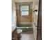 This bathroom has a green tub, shelves, a window, and a toilet at 186 Frank Cash Rd, Timberlake, NC 27583