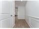 Inviting hallway featuring wainscoting and wood-look flooring, leading to the open-concept living spaces at 192 Bruce Dr, Dunn, NC 28334