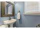 Charming half bath with pedestal sink, decorative mirror, and window for natural light at 201 Timber Meadow Lk, Fuquay Varina, NC 27526