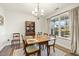 Elegant dining room with a chandelier, a china cabinet, and large window view at 201 Timber Meadow Lk, Fuquay Varina, NC 27526