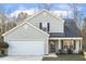 Charming two-story home with a well-manicured lawn, attached garage, and a cozy front porch sitting area at 201 Timber Meadow Lk, Fuquay Varina, NC 27526