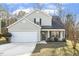 Charming two-story home with a well-manicured lawn, attached garage, and a cozy front porch sitting area at 201 Timber Meadow Lk, Fuquay Varina, NC 27526