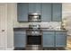 Modern kitchen showcases stainless steel appliances, gas range, microwave and shaker style blue cabinets at 201 Timber Meadow Lk, Fuquay Varina, NC 27526