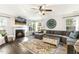 Inviting living room with fireplace, large sectional sofa, and stylish rug beneath a ceiling fan at 201 Timber Meadow Lk, Fuquay Varina, NC 27526