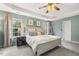Bright bedroom featuring a tray ceiling, large bed, and natural light at 201 Timber Meadow Lk, Fuquay Varina, NC 27526