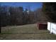 Backyard featuring a large grassy lawn and wooded area beyond at 2110 Carolina Mill Rd, Burlington, NC 27217