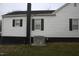 Side of the home featuring white siding, black trim, and a modern HVAC system at 2110 Carolina Mill Rd, Burlington, NC 27217