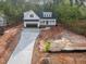 Aerial view of a charming two-story home with a concrete driveway surrounded by trees at 215 Purslane Dr, Franklinton, NC 27525