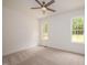 Bright, neutral bedroom featuring plush carpet, two windows and a ceiling fan at 215 Purslane Dr, Franklinton, NC 27525
