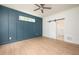 Bright bedroom with blue accent wall, two large windows, hardwood floor, and sliding door closet at 215 Purslane Dr, Franklinton, NC 27525