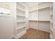 Walk-in closet featuring custom shelving, wood floor, and natural light at 215 Purslane Dr, Franklinton, NC 27525