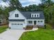 Charming two-story home with a pristine white exterior, attached garage, and beautifully landscaped front yard at 215 Purslane Dr, Franklinton, NC 27525