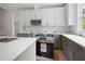 Modern kitchen featuring a center island, stainless steel appliances, white upper cabinets, and gray lower cabinets at 215 Purslane Dr, Franklinton, NC 27525