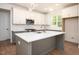 Bright kitchen featuring an island with a sink, white cabinets, and stainless steel appliances at 215 Purslane Dr, Franklinton, NC 27525