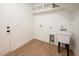 Clean, well-lit laundry room with a utility sink, built-in shelving, and wood-look flooring at 215 Purslane Dr, Franklinton, NC 27525