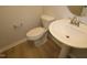 Well-lit bathroom with a sleek pedestal sink, modern toilet, and neutral-toned flooring creating a clean and comfortable space at 2454 Englemann Dr # 380, New Hill, NC 27562