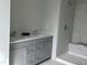 Bathroom showcasing a double vanity with gray cabinets and a tiled walk-in shower at 2454 Englemann Dr # 380, New Hill, NC 27562