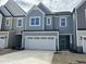 Charming two-story home with a two car garage, light blue exterior, and neatly landscaped yard at 2454 Englemann Dr # 380, New Hill, NC 27562