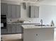 Modern kitchen boasts gray cabinets, white countertops, stainless steel appliances, and a stylish tile backsplash at 2454 Englemann Dr # 380, New Hill, NC 27562