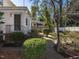 Backyard featuring manicured bushes and a brick walkway leading toward a white gazebo at 2521 St Mary'S St, Raleigh, NC 27609