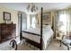 Charming bedroom with a four-poster bed, floral curtains, and a vintage-style chandelier at 2521 St Mary'S St, Raleigh, NC 27609
