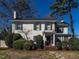 Attractive two-story home with white brick, complemented by lush greenery and a clear blue sky at 2521 St Mary'S St, Raleigh, NC 27609