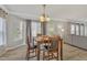 Cozy dining area featuring a wood table and four chairs under a charming chandelier at 3100 Cynthiana Ct, Raleigh, NC 27610