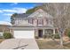 Charming two-story home with a stone and siding facade, red shutters, a well-manicured lawn, and an attached two-car garage at 3100 Cynthiana Ct, Raleigh, NC 27610