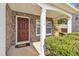 Inviting covered entryway with a stone facade, a painted door, green landscaping, and the house number displayed at 3100 Cynthiana Ct, Raleigh, NC 27610