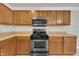 Close-up of kitchen with wooden cabinetry, stainless steel appliances, and ample countertop area at 3100 Cynthiana Ct, Raleigh, NC 27610
