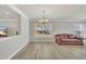 Spacious living room featuring vinyl flooring, neutral wall paint, a chandelier, and large windows with blinds at 3100 Cynthiana Ct, Raleigh, NC 27610
