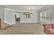 Spacious living room featuring vinyl flooring, neutral wall paint, stairs, a chandelier, and large windows with blinds at 3100 Cynthiana Ct, Raleigh, NC 27610
