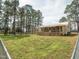 Home exterior with a spacious fenced-in yard, wooden deck, and view of mature trees at 3130 State Hwy 58, Louisburg, NC 27549