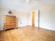 Bedroom featuring hardwood floors, dresser, and a view into the hallway at 3130 State Hwy 58, Louisburg, NC 27549