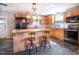 Spacious kitchen with wood cabinets, black appliances and a large island with seating at 3130 State Hwy 58, Louisburg, NC 27549