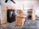 Kitchen view with wood cabinets, black appliances and an island with seating at 3130 State Hwy 58, Louisburg, NC 27549