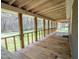 Spacious covered porch with wooden floors and railings, perfect for outdoor relaxation at 3130 State Hwy 58, Louisburg, NC 27549