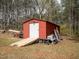 A red storage shed equipped with a ramp, offering ample storage space at 3130 State Hwy 58, Louisburg, NC 27549