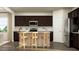 Stylish kitchen boasts dark cabinets, stainless steel appliances, granite countertops, and an island with seating at 3725 Massey Pond Trl, Raleigh, NC 27616