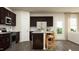 Spacious kitchen with an island, dark cabinets, stainless appliances, granite countertops, and hardwood floors at 3725 Massey Pond Trl, Raleigh, NC 27616