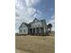 Beautiful gray home with a welcoming front porch, white columns and trim, and meticulously maintained lawn at 405 Rising Star Dr, Clayton, NC 27520