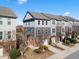 Inviting two-story townhome with a one-car garage, brick accents, landscaping, and gray wood-look siding at 4116 Sykes St, Cary, NC 27519