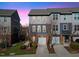 Charming two-story townhome featuring a one-car garage, brick accents, and gray wood-look siding at 4116 Sykes St, Cary, NC 27519