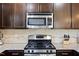 Kitchen featuring stainless steel appliances, granite countertops, and dark wood cabinets at 4116 Sykes St, Cary, NC 27519