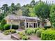 Community clubhouse at 500 Umstead Dr, D105, with pergola covered entry, surrounded by mature landscaping and colorful flower beds at 500 Umstead Dr # 105D, Chapel Hill, NC 27516