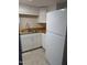 Well-lit kitchen featuring white cabinets, wooden countertops, stainless steel sink and a modern refrigerator at 500 Umstead Dr # 105D, Chapel Hill, NC 27516